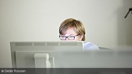 Eine Person hinter einem Bildschirm